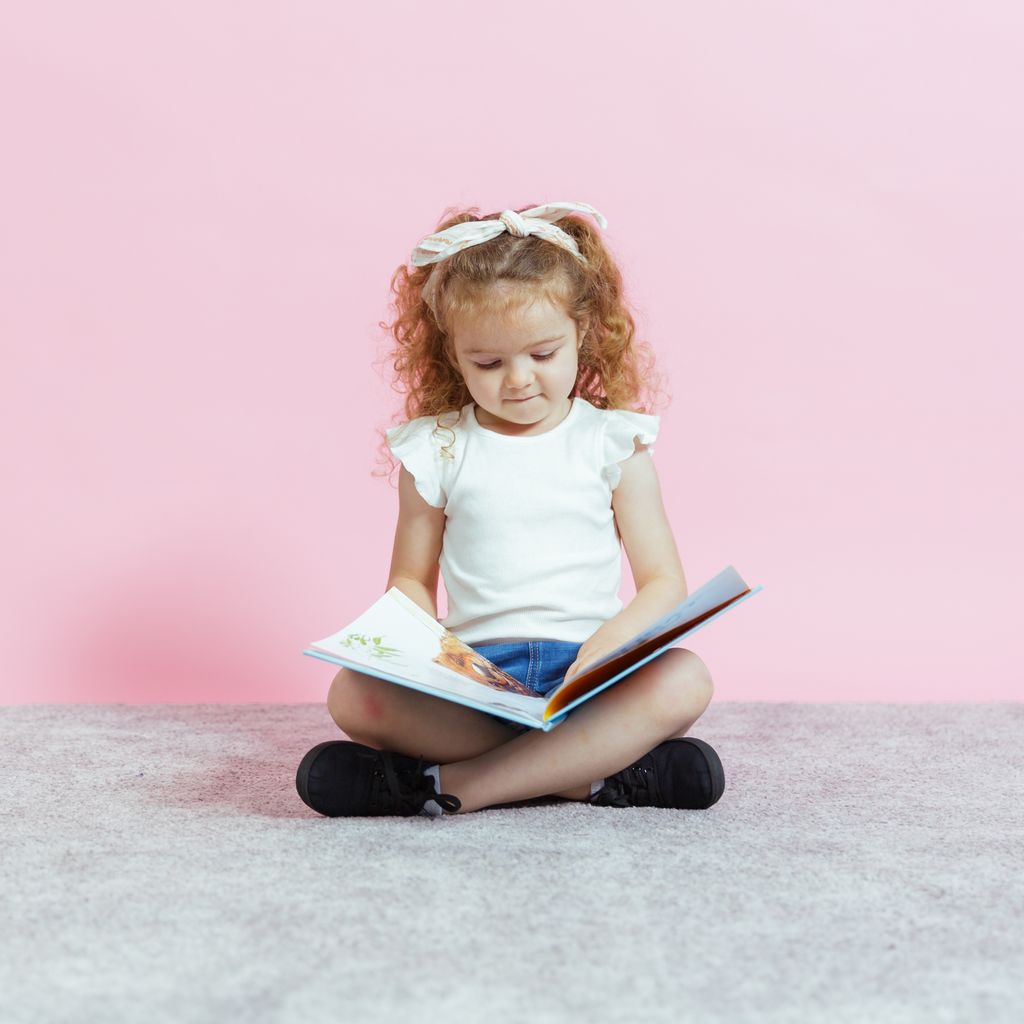 A child reading a book at the child care centre, emphasizing learning and care in their childcare services